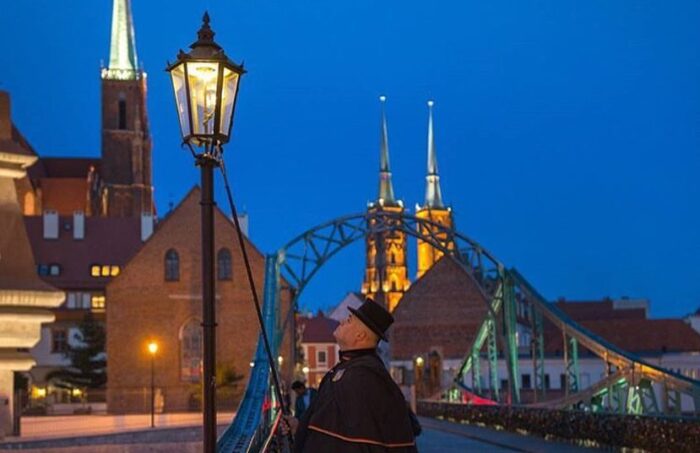 Na zdjęciu latarnik zapalający lampę na Ostrowie Tumskim /Janusz Krzeszowski