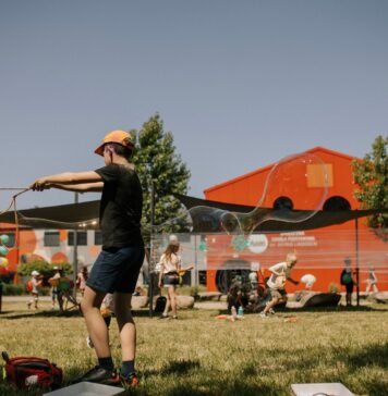 Szukasz pomysłu na rodzinny wakacyjny wypad? Sprawdź Dolinę Baryczy! Na zdjęciu dziecko puszczające bańki