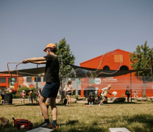 Szukasz pomysłu na rodzinny wakacyjny wypad? Sprawdź Dolinę Baryczy! Na zdjęciu dziecko puszczające bańki