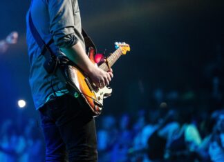 Jak dojechć na Męskie Granie 2025? Kolejny dzień muzycznej imprezy we Wrocławiu! Na zdjęciu gitarzysta podczas koncertu